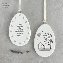 Load image into Gallery viewer, Porcelain Flat Hanging Ceramic Egg with message 'Look towards the sun and the shadows will fall behind.